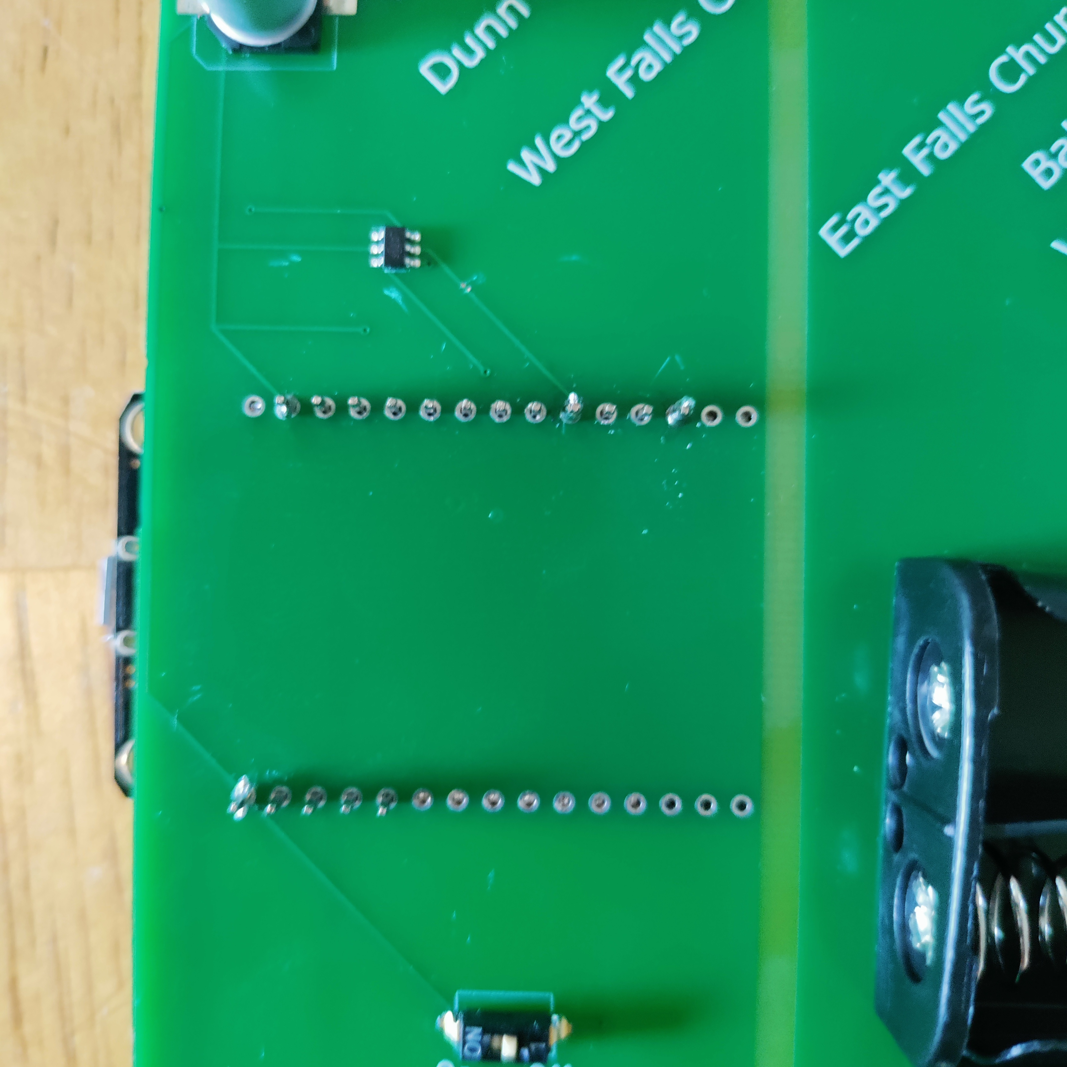 Close-up photo of the through-holes on the front of the board where the chip is soldered on, showing heat marks and pins that were cut off to allow an easier connection.